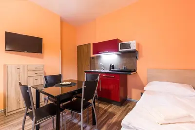 a small kitchen with a table and a bed in a room at Rezidence Davids Apartments in Prague