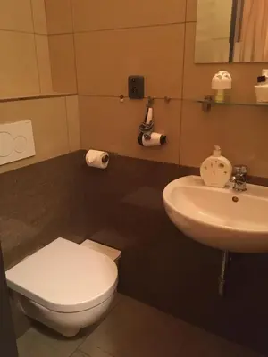 a bathroom with a white toilet and a sink at Rezidence Davids Apartments in Prague