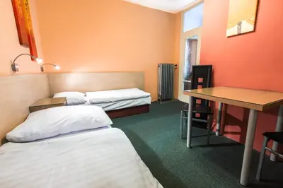 a hotel room with two beds and a desk at Rezidence Davids Apartments in Prague