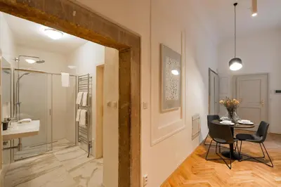a bathroom with a table and chairs and a sink at Lazenska N4 Residence in Prague