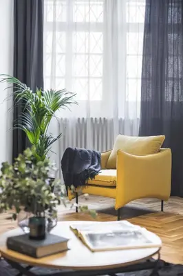 a living room with a yellow couch and a table at Lazenska N4 Residence in Prague