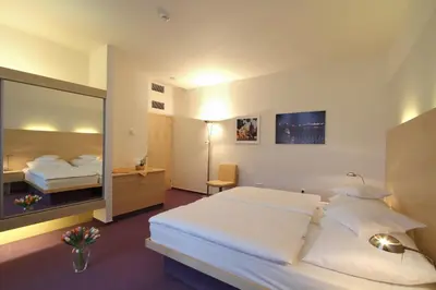 a hotel room with a large bed and a mirror at Hotel DAP in Prague