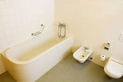 a bathroom with a bath tub and a toilet at Hotel DAP in Prague