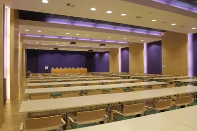 an empty lecture hall with rows of tables and chairs at Hotel DAP in Prague
