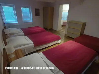 a bedroom with three beds with red sheets at DN Pub Apartments in Prague