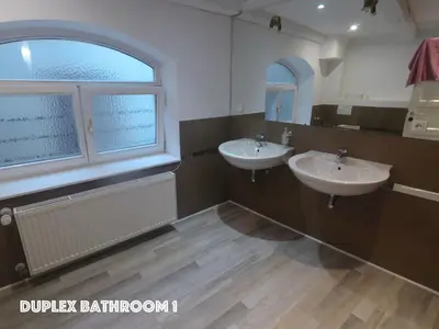 a bathroom with two sinks and a large window at DN Pub Apartments in Prague