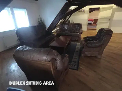 a living room with two leather chairs and a table at DN Pub Apartments in Prague