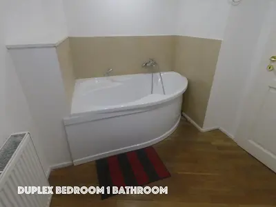 a white bath tub in a bathroom with a red rug at DN Pub Apartments in Prague