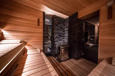 a room with a sauna with a stone wall at Volcano Spa Hotel in Prague