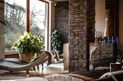 a living room with a chair and a fireplace at Volcano Spa Hotel in Prague