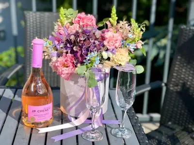a table with two wine glasses and a vase of flowers at Grand Petit Hotel ex Shato Gesson in Prague