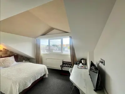 a bedroom with a bed and a desk with a television at Grand Petit Hotel ex Shato Gesson in Prague