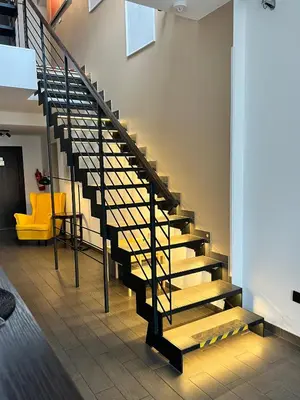 a staircase in a building with a yellow chair at Grand Petit Hotel ex Shato Gesson in Prague