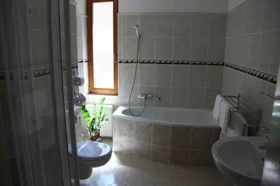 a bathroom with a tub and a toilet and a sink at Lazensky Hotel Park in Poděbrady