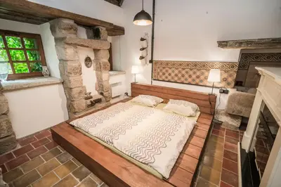 a large bed in a room with a fireplace at Luxusní srub Líny in Bukovno