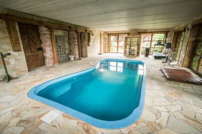 a large swimming pool in a room with at Luxusní srub Líny in Bukovno
