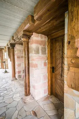 a room with a brick wall and a wooden door at Luxusní srub Líny in Bukovno