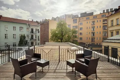 a balcony with chairs and a table and buildings at Elizabeth Suites in Prague