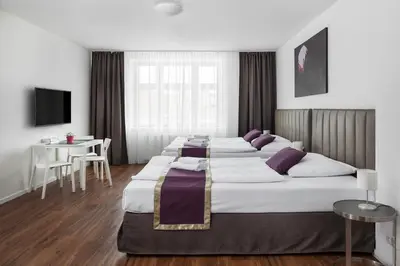 a group of four beds in a hotel room at Elizabeth Suites in Prague