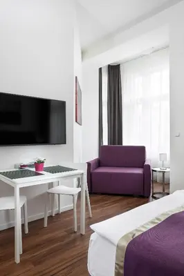 a hotel room with a purple couch and a table at Elizabeth Suites in Prague