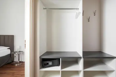a bedroom with a closet with a bed and a desk at Elizabeth Suites in Prague