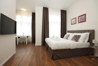 a bedroom with a bed and a flat screen tv at Elizabeth Suites in Prague