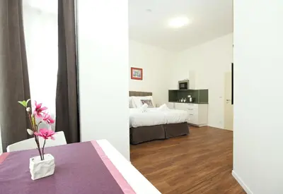 a bedroom with a bed and a table with a vase on it at Elizabeth Suites in Prague