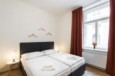 a bedroom with a large bed and a window at Rehorova apartments by Pragueforyou in Prague