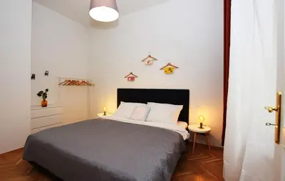 a bedroom with a bed and two lights on the wall at Rehorova apartments by Pragueforyou in Prague