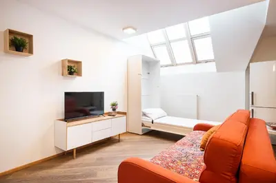 a living room with a couch and a tv at Rehorova apartments by Pragueforyou in Prague