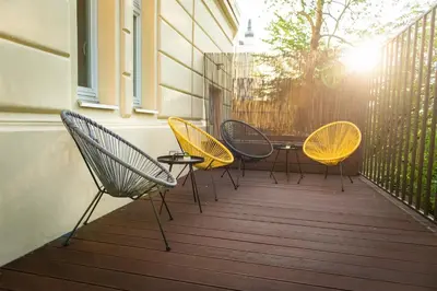 four chairs and a table on a balcony at Rehorova apartments by Pragueforyou in Prague