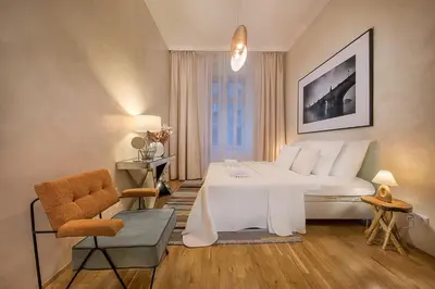 a bedroom with a large white bed and a chair at Prague Days - Luxurious Apartments Lesser Town in Prague