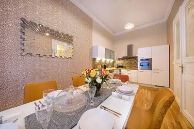 a dining room with a table with flowers on it at Prague Days - Luxurious Apartments Lesser Town in Prague
