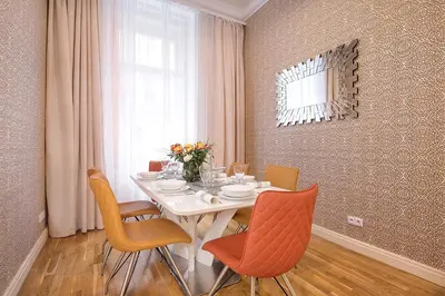 a dining room with a white table with orange chairs at Prague Days - Luxurious Apartments Lesser Town in Prague