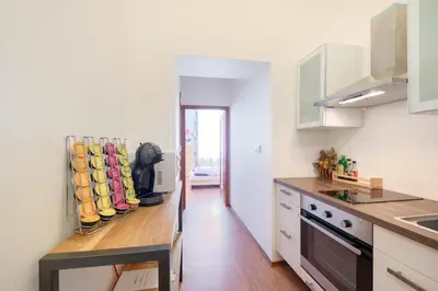 a kitchen with white cabinets and a wooden counter top at Paradise Apartment in Prague