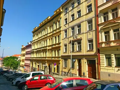a street with cars parked in front of buildings at Paradise Apartment in Prague