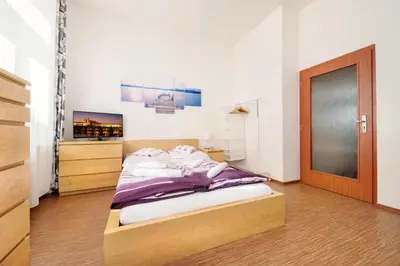 a bedroom with a bed and a wooden door at Paradise Apartment in Prague