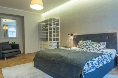 a bedroom with a large bed and a chair at Exclusive 3 Bedroom Top-Notch Flat, GREAT LOCATION in Prague