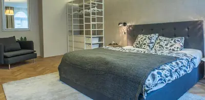 a bedroom with a large bed and a chair at Exclusive 3 Bedroom Top-Notch Flat, GREAT LOCATION in Prague