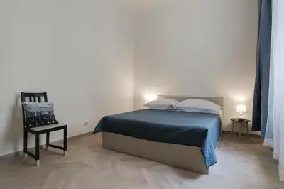 a bedroom with a bed and a chair in it at Vita Nejedleho apartments in Prague