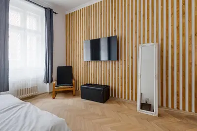 a bedroom with a mirror and a tv on the wall at Vita Nejedleho apartments in Prague