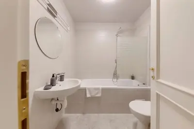a white bathroom with a sink and a tub and a toilet at Vita Nejedleho apartments in Prague