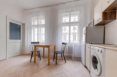 a kitchen and dining room with a table and chairs at Vita Nejedleho apartments in Prague