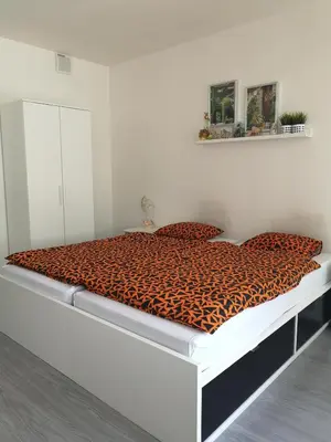 a bed in a white room with a tiger print blanket at Nice and refreshing flat in Prague in Prague