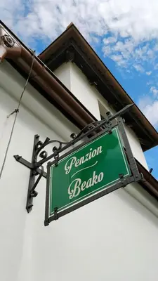 a green sign hanging from the side of a building at Penzion BEAKO na 