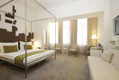 a bedroom with a canopy bed and a couch at Pure White in Prague