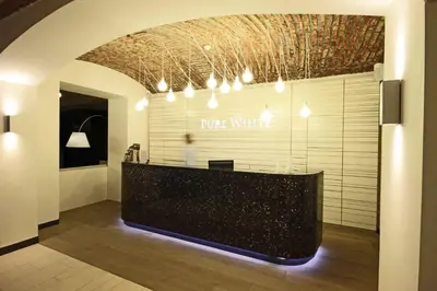 a long black counter in a room with lights at Pure White in Prague