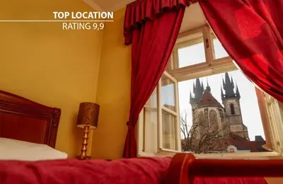 a bedroom with a window with a view of a church at Josephine Old Town Square Hotel - Czech Leading Hotels in Prague