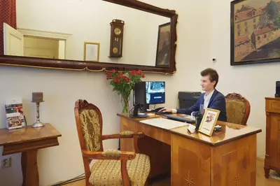 a man sitting at a desk with a computer at Josephine Old Town Square Hotel - Czech Leading Hotels in Prague