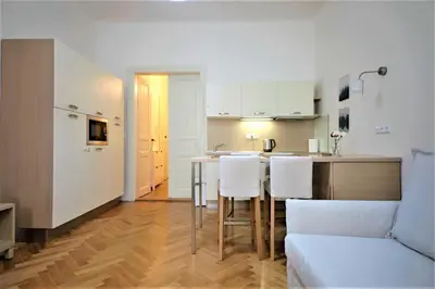 a kitchen and living room with a table and a couch at City Castle Aparthotel in Prague